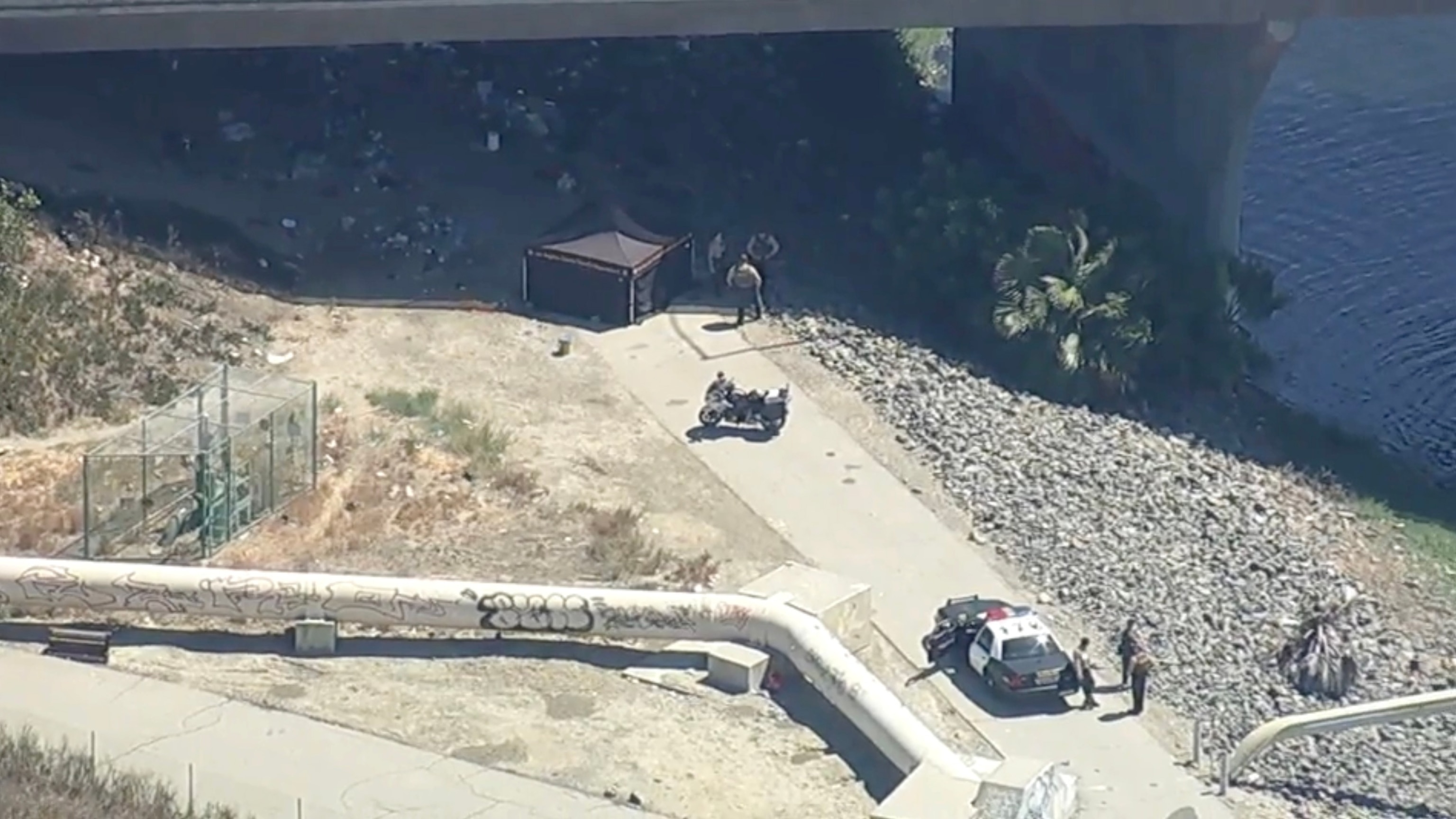 In this screen grab from a video, law enforcement officers are shown at the scene where two bodies were found along the Dominguez Channel in Carson, Calif., on Sept. 1, 2026.KABC