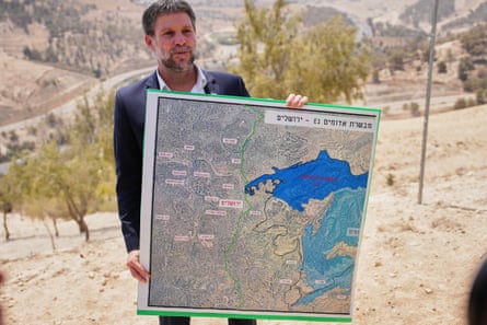 Israeli finance minister Bezalel Smotrich standing near the settlement of Ma’ale Adumim, in the Israeli-occupied West Bank, holding a map showing the E1 settlement project.Photograph: Ohad Zwigenberg/AP