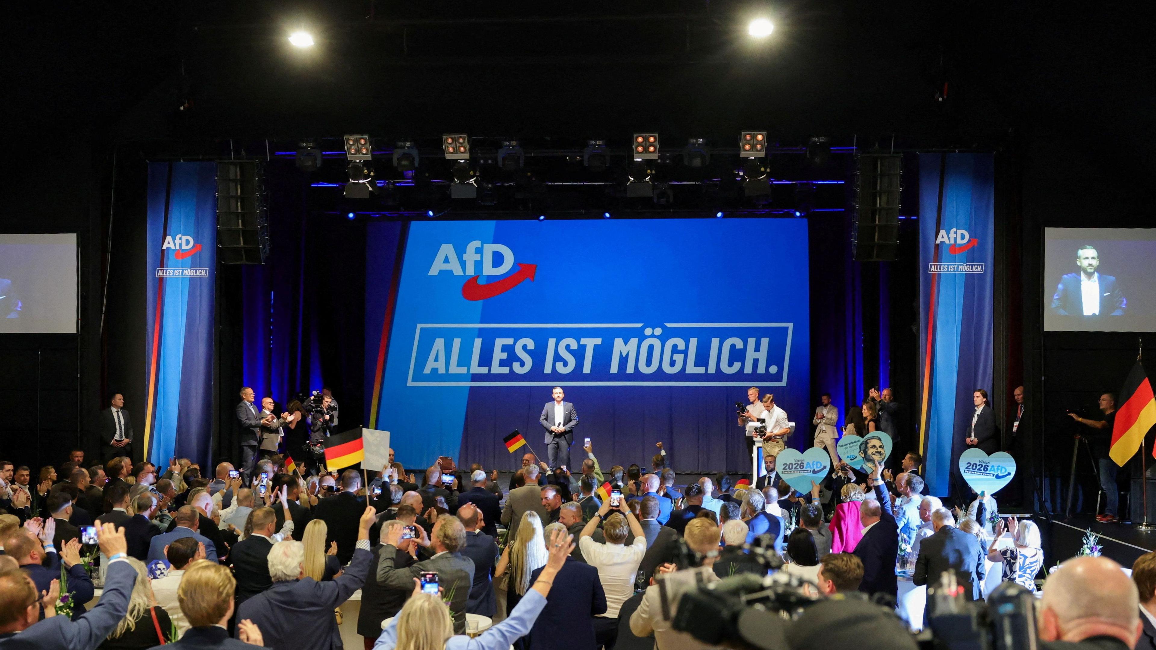Image caption,Crowds waved German flags at the election party after polls closed, where the AfD motto 'anything is possible' was displayed