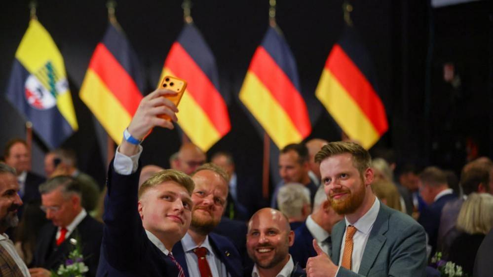 Image caption,Supporters cheered and took selfies as the extent of the AfD's victory became clear