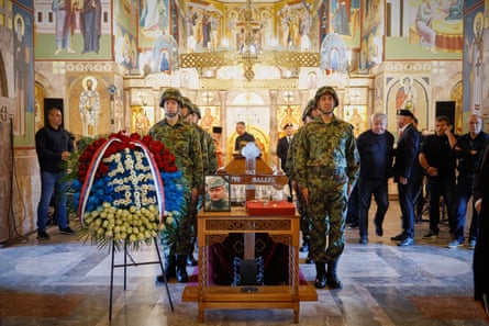 People gather to watch the funeral service outside the church.Photograph: Darko Vojinović/AP