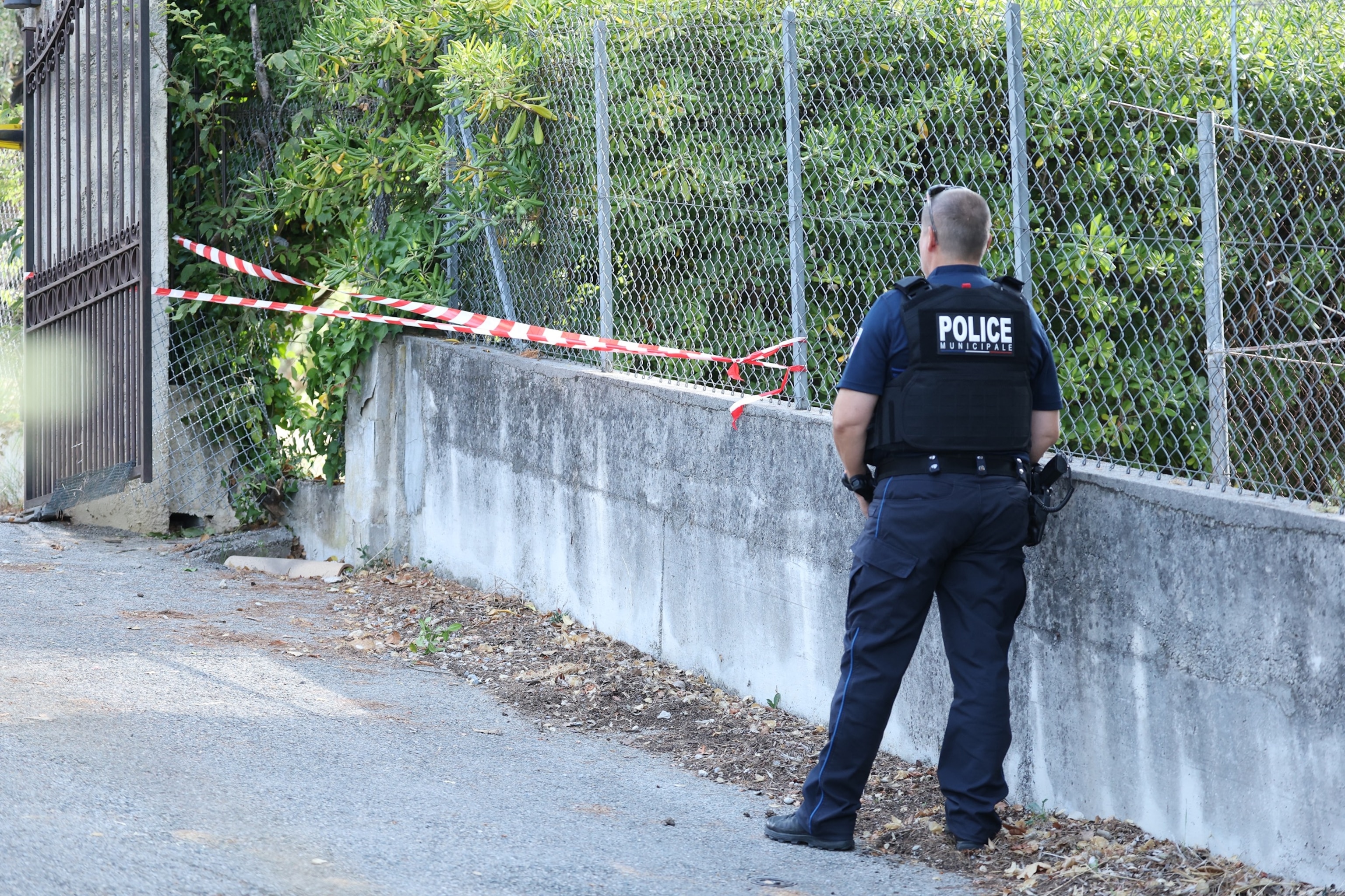A police officer stands near a hole cut by the thieves in the outer fence of the Musee Renoir after four paintings, together valued at nine million euros, were stolen in an early-morning break-in, with one recovered nearby and two suspects still at large, in Cagnes-sur-Mer on Sept. 8, 2026.Valery Hache/AFP via Getty Images